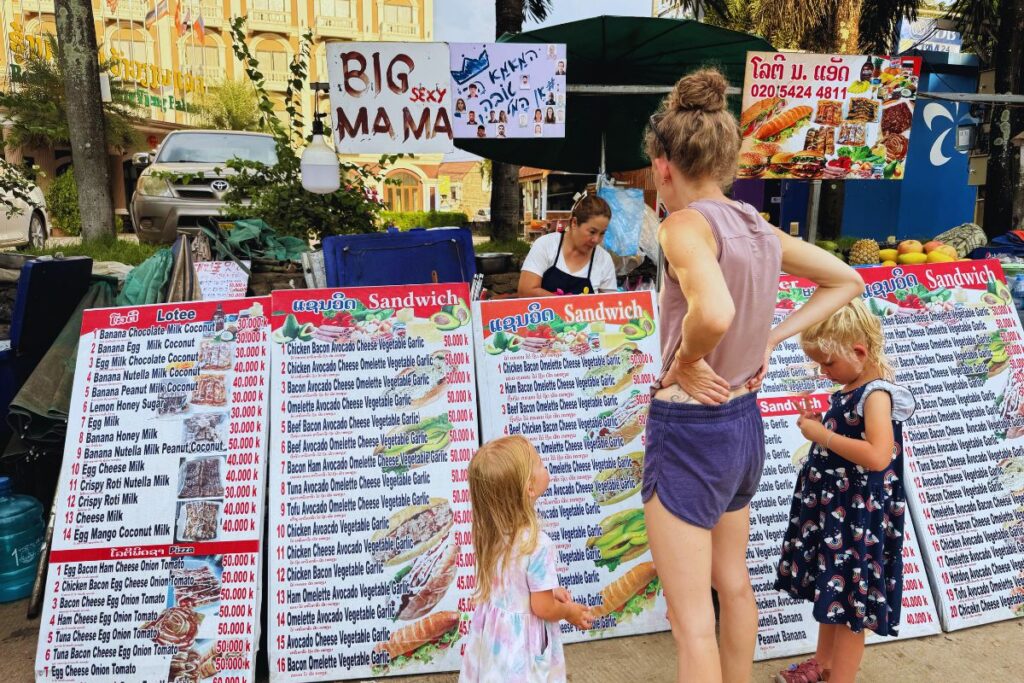outdoor food vendor stall with signs of their food