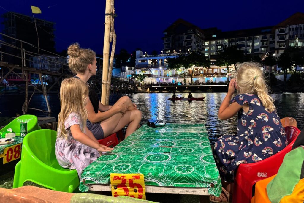 sitting on the river at night at a dinner table