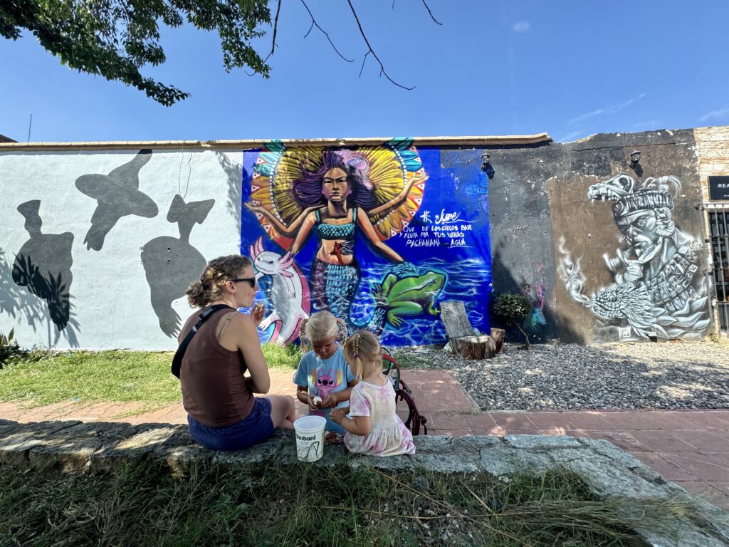 family eating a snack in front of a wall mural