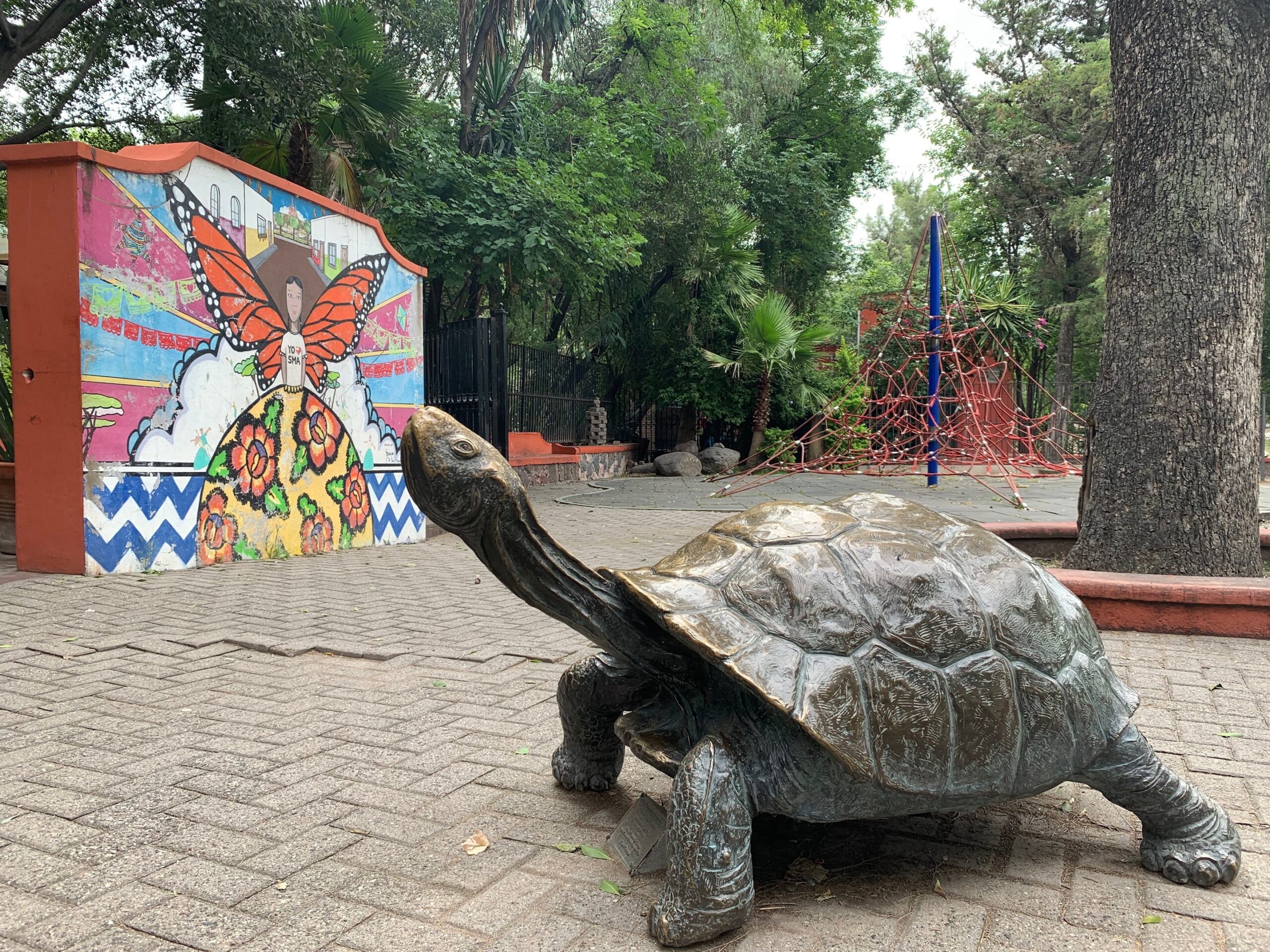 Turtle sculpture with a monarch butterfly mural in the background