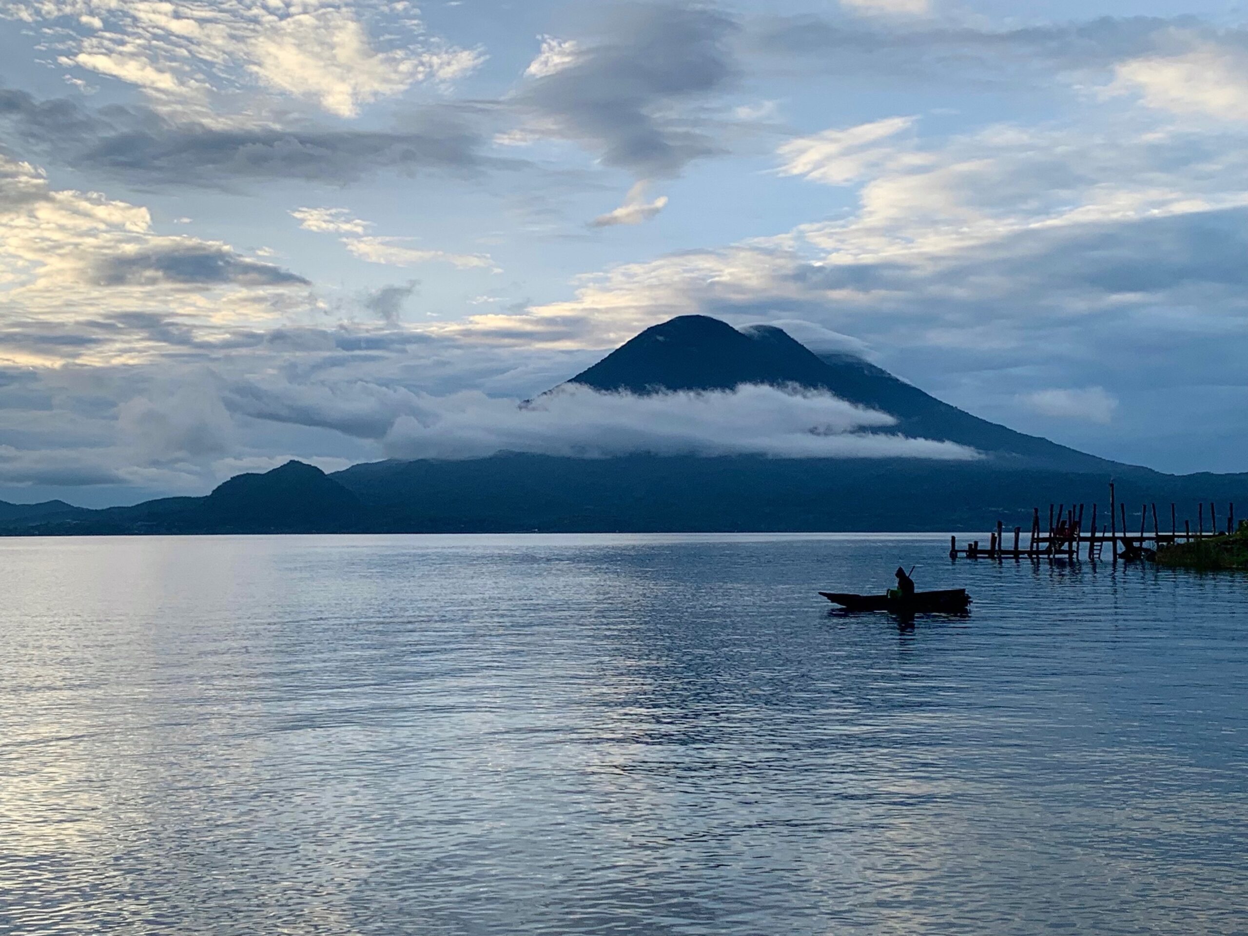 small boat on a lake with volcano views