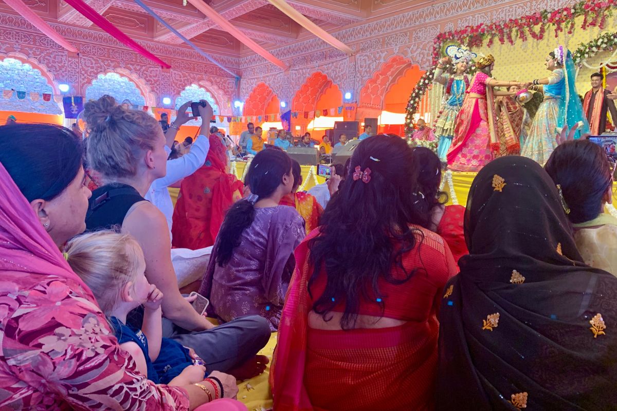 colorful dresses with people sitting on floor watching a performance