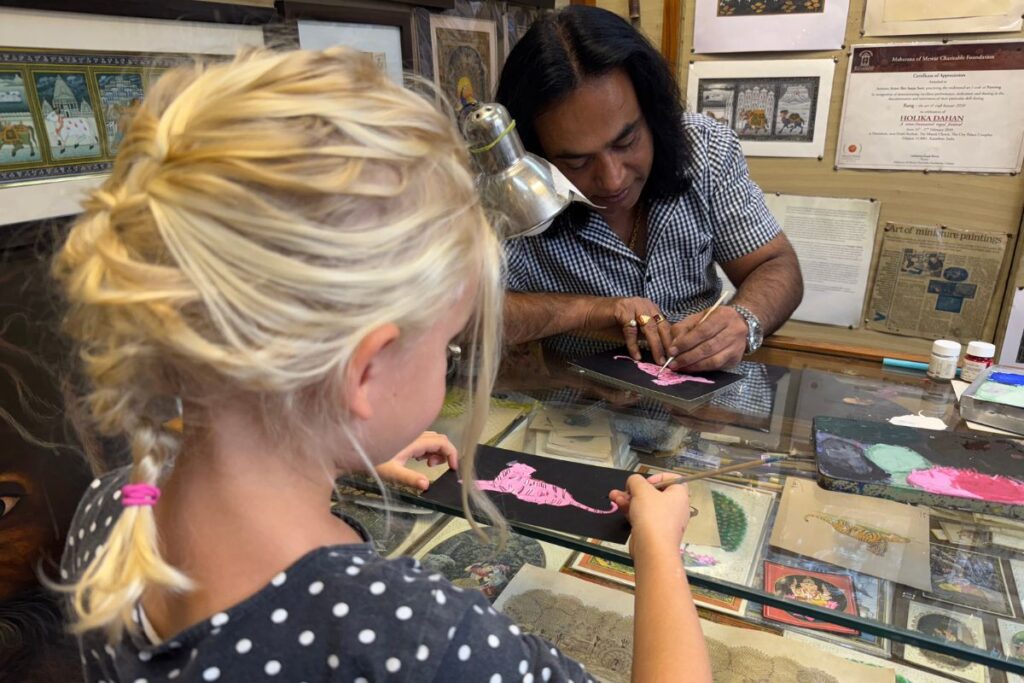 girl painting miniature art with teacher