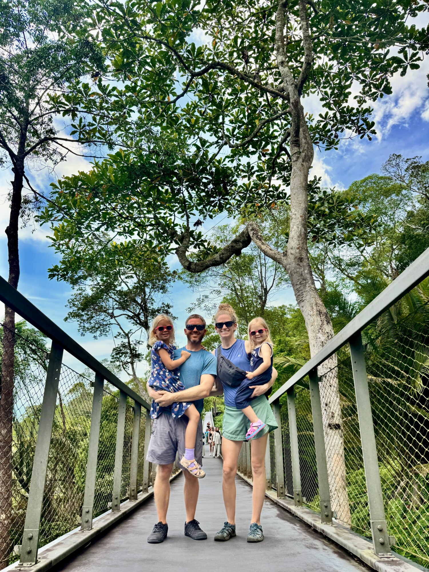 family of four posing on a bridge in a jungle