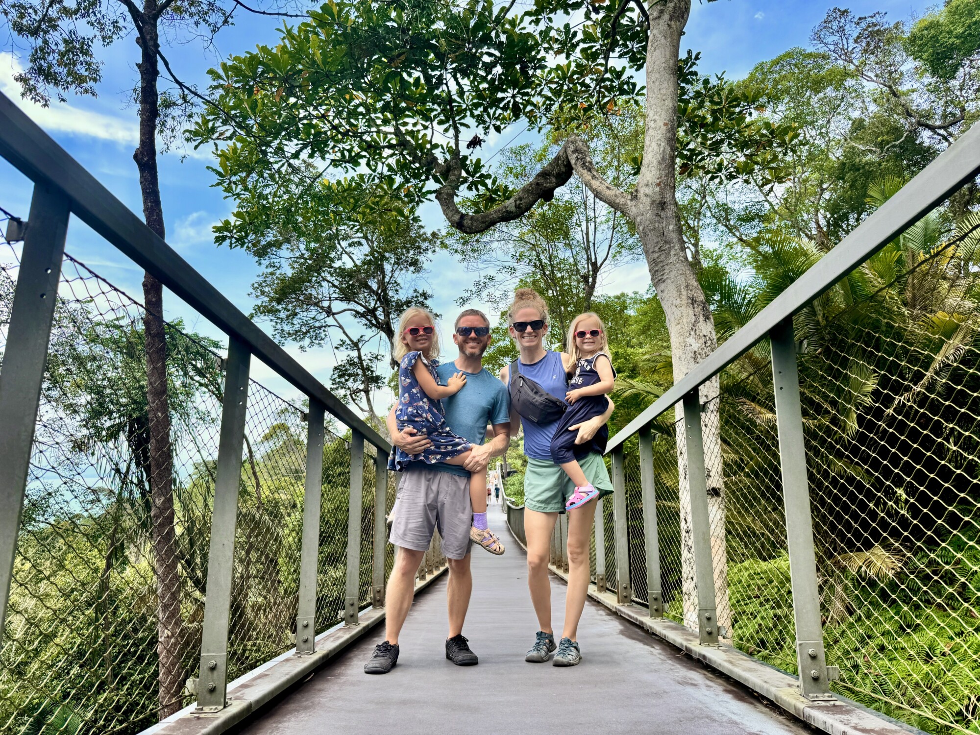 family of four posing on a bridge in a jungle