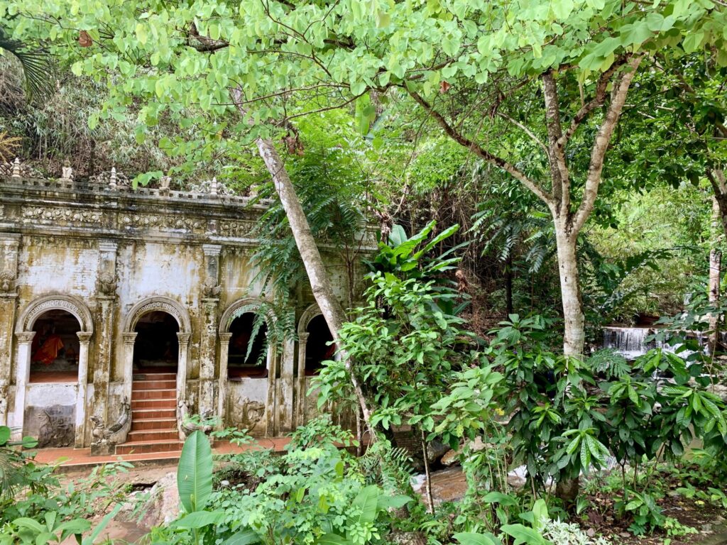 temple in a jungle with a waterfall and stream flowing past