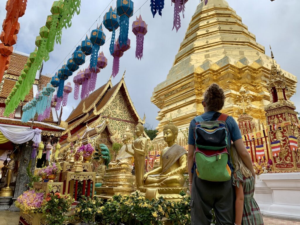 mother and daughter looking at a golden Buddhist pagoda
