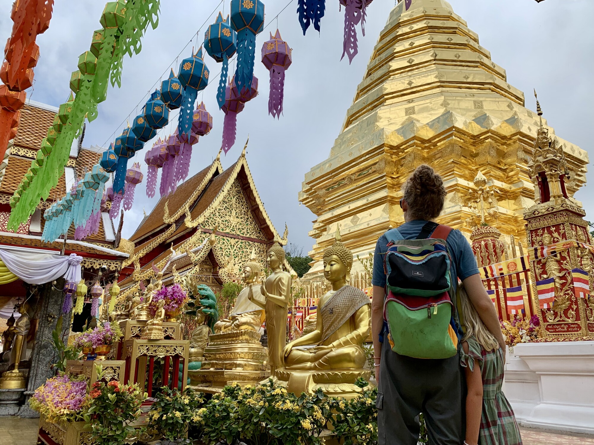 mother and daughter looking at a golden Buddhist pagoda