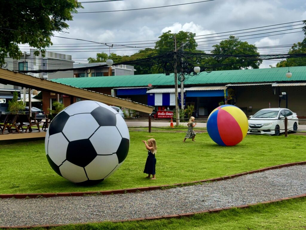 large blow up ball with kids playing in grass