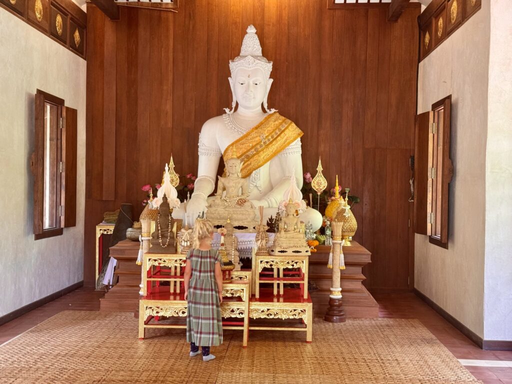 girl in a Buddhist temple admiring a Buddha statue