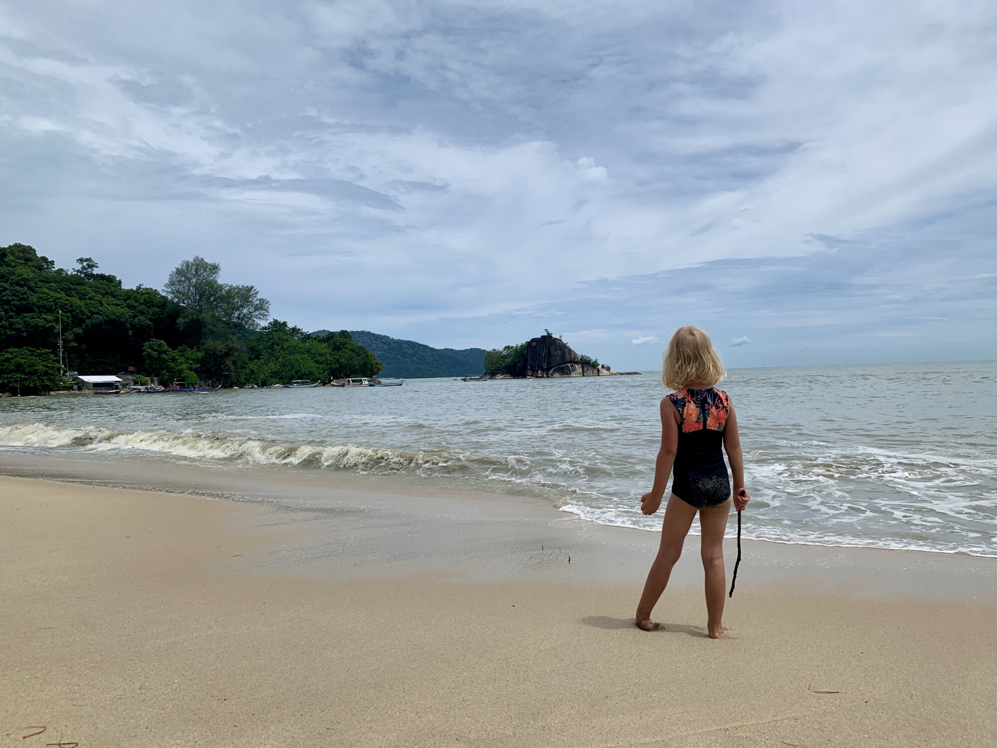 girls standing on a beach looking at the ocean