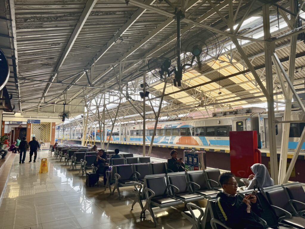 people sitting in chairs at a train station terminal
