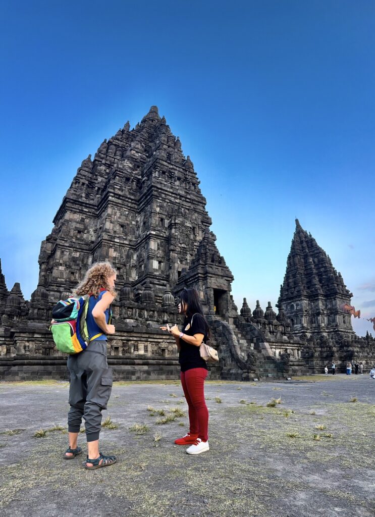 one woman teaching another woman in front of a temple