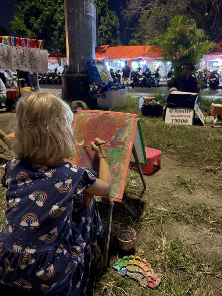 girl painting on an easel in a park