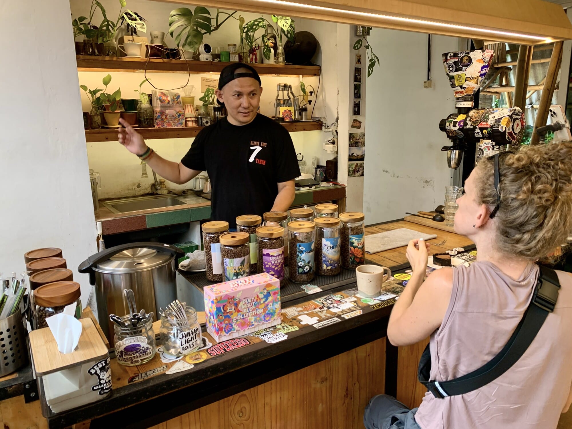man teaching a woman about coffee with many types of coffee beans on a table