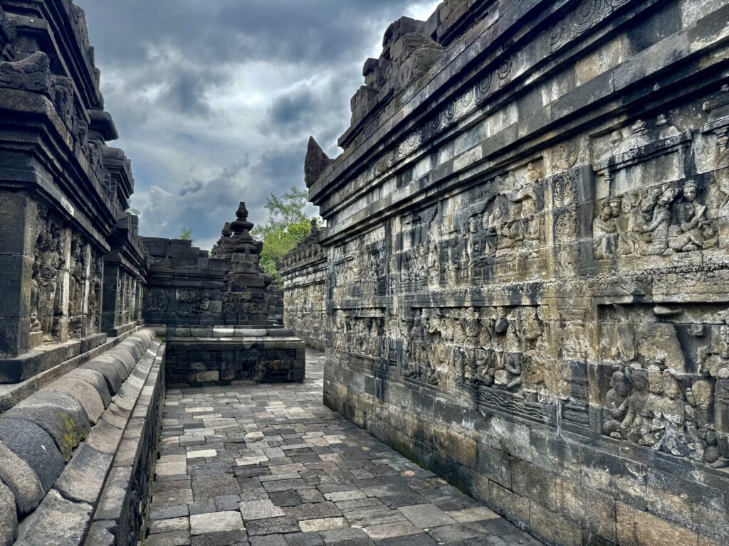 walkway of a Buddhist temple with carvings on the walls