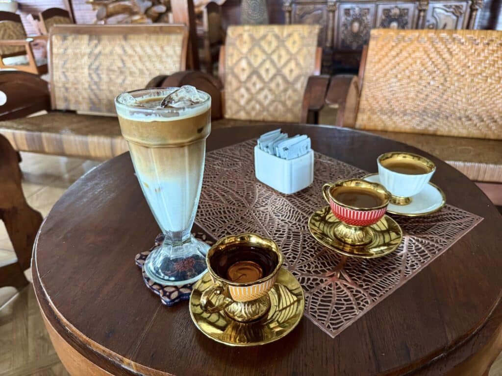 4 coffee cups on an ornate wooden table