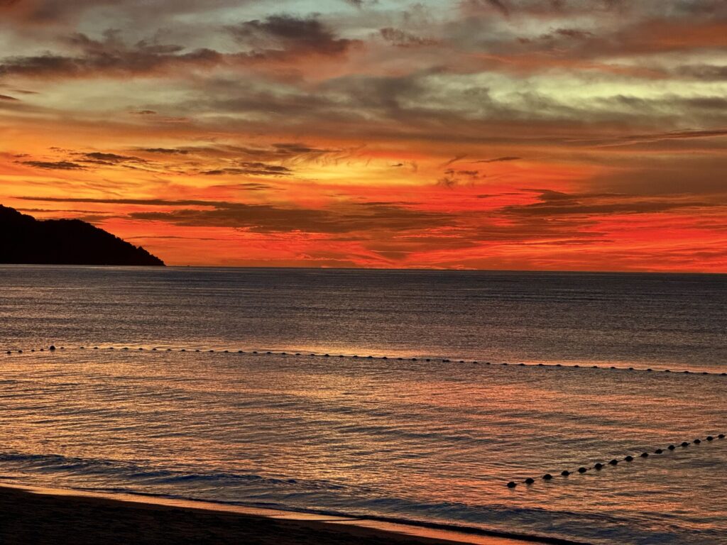 vivid orange and red sunset over a beach scene