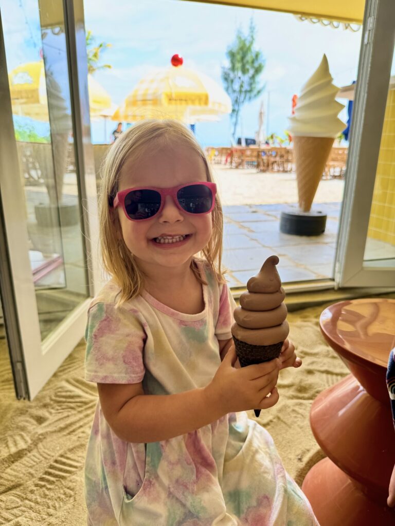 child holding a large chocolate ice cream cone