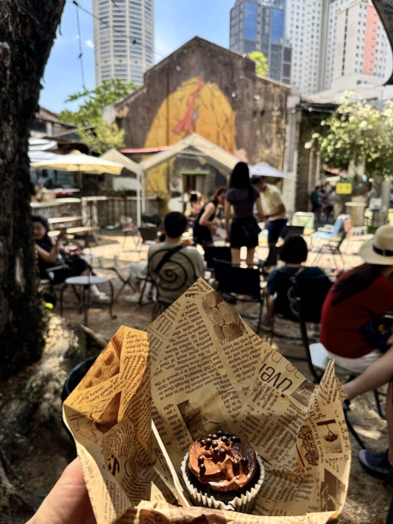 a chocolate cupcake with a mural in the background