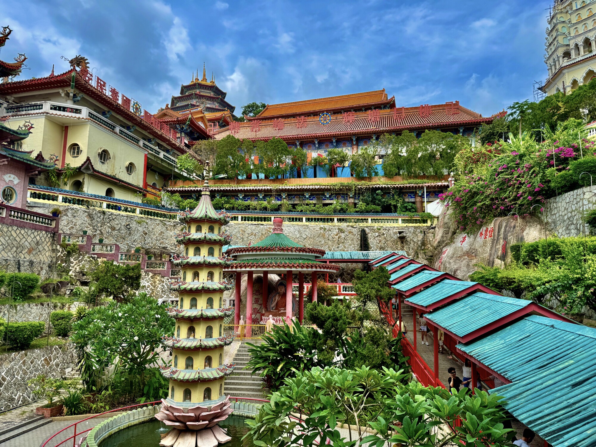 large Buddhist temple complex with pagodas, covered walk way, Buddhist statue