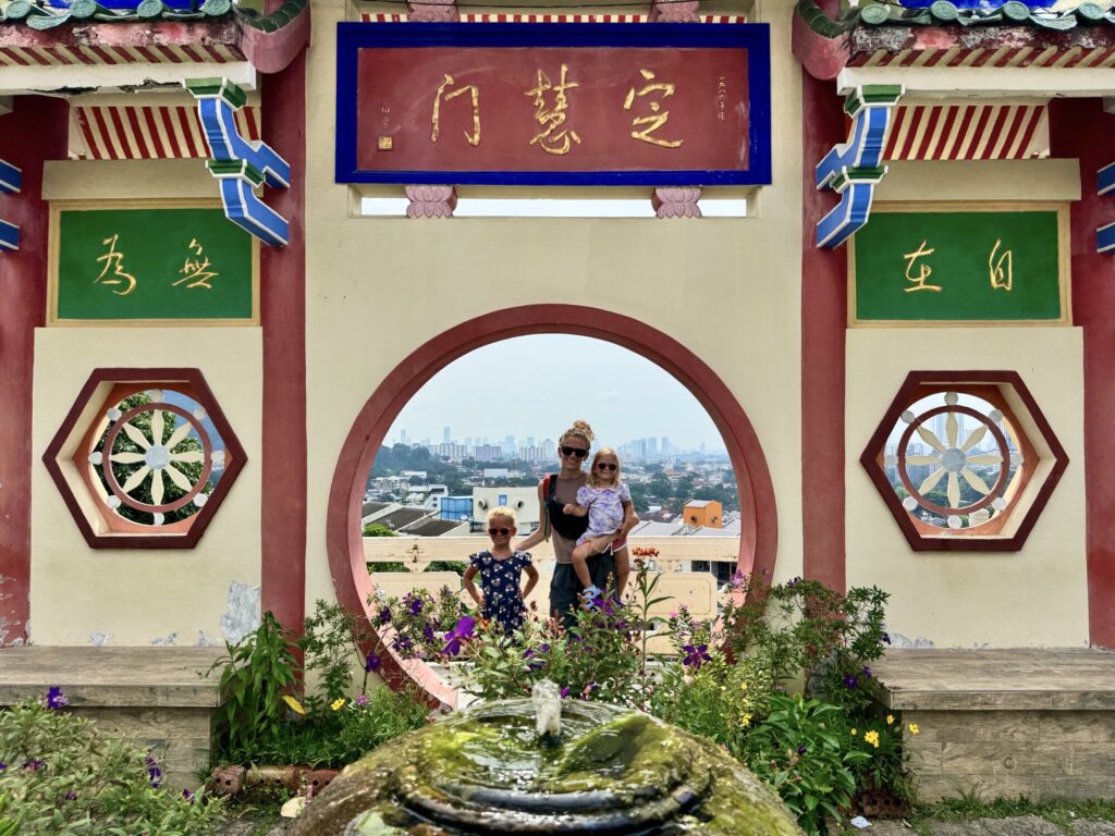 family posing in a circular doorway outside of a Buddhist temple