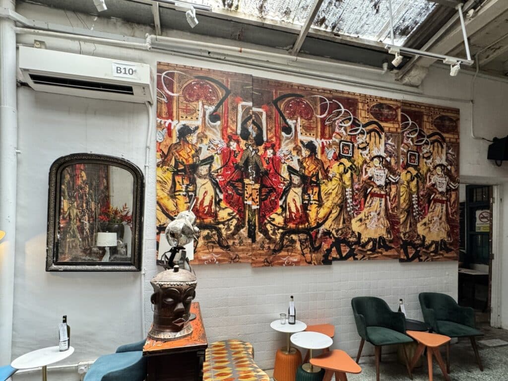 mural that is vandalized hanging as artwork in a cafe