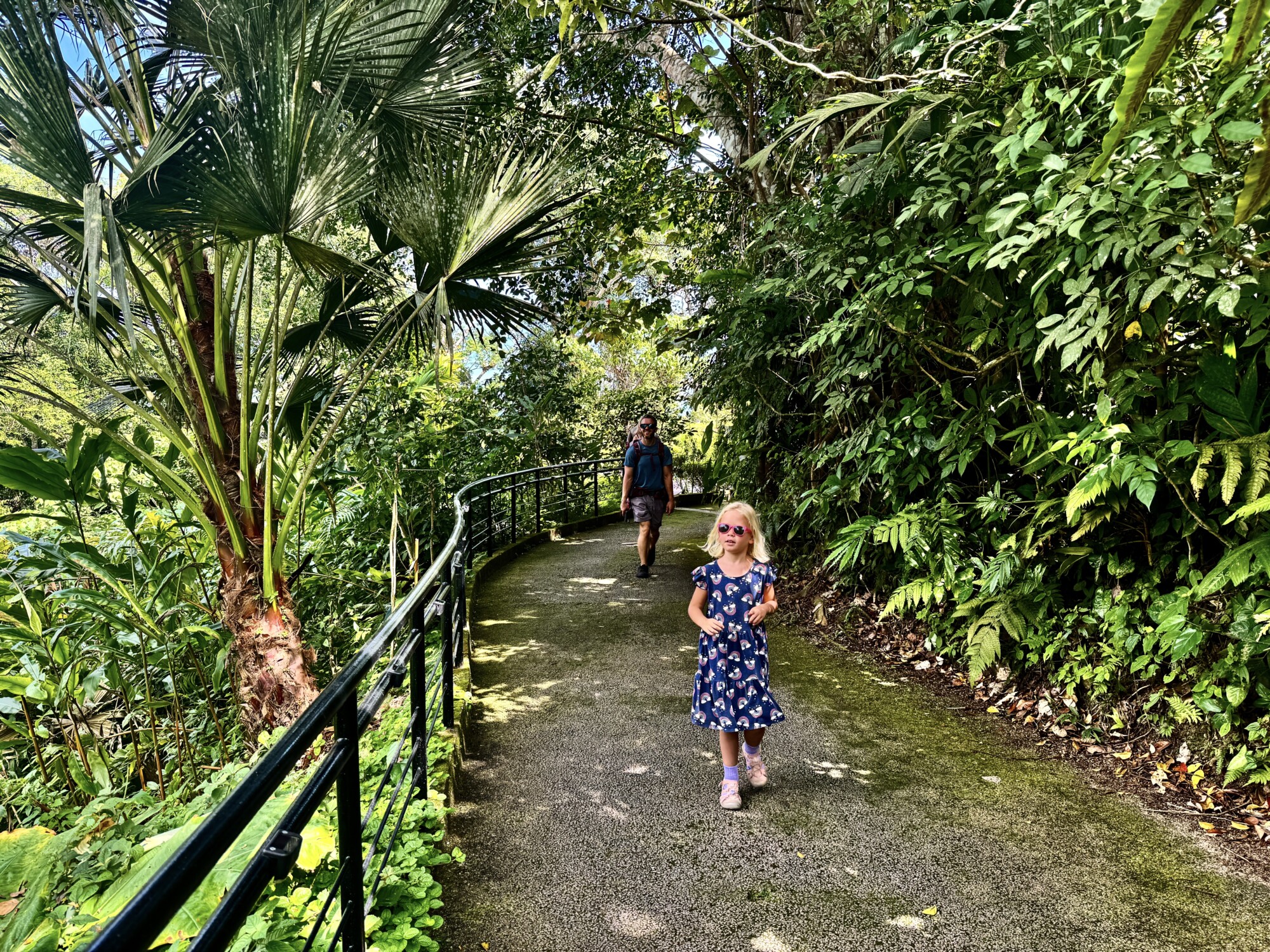 girl and father walking on a path in a jungle