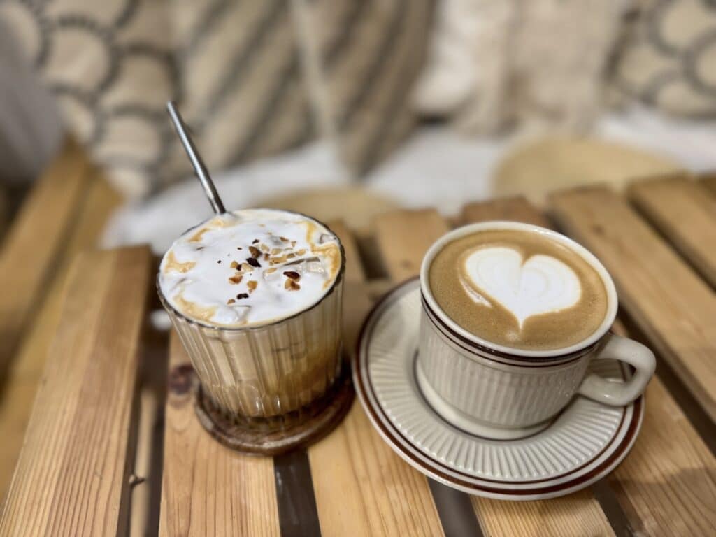 a cup of caramel coffee and white coffee late with a heart