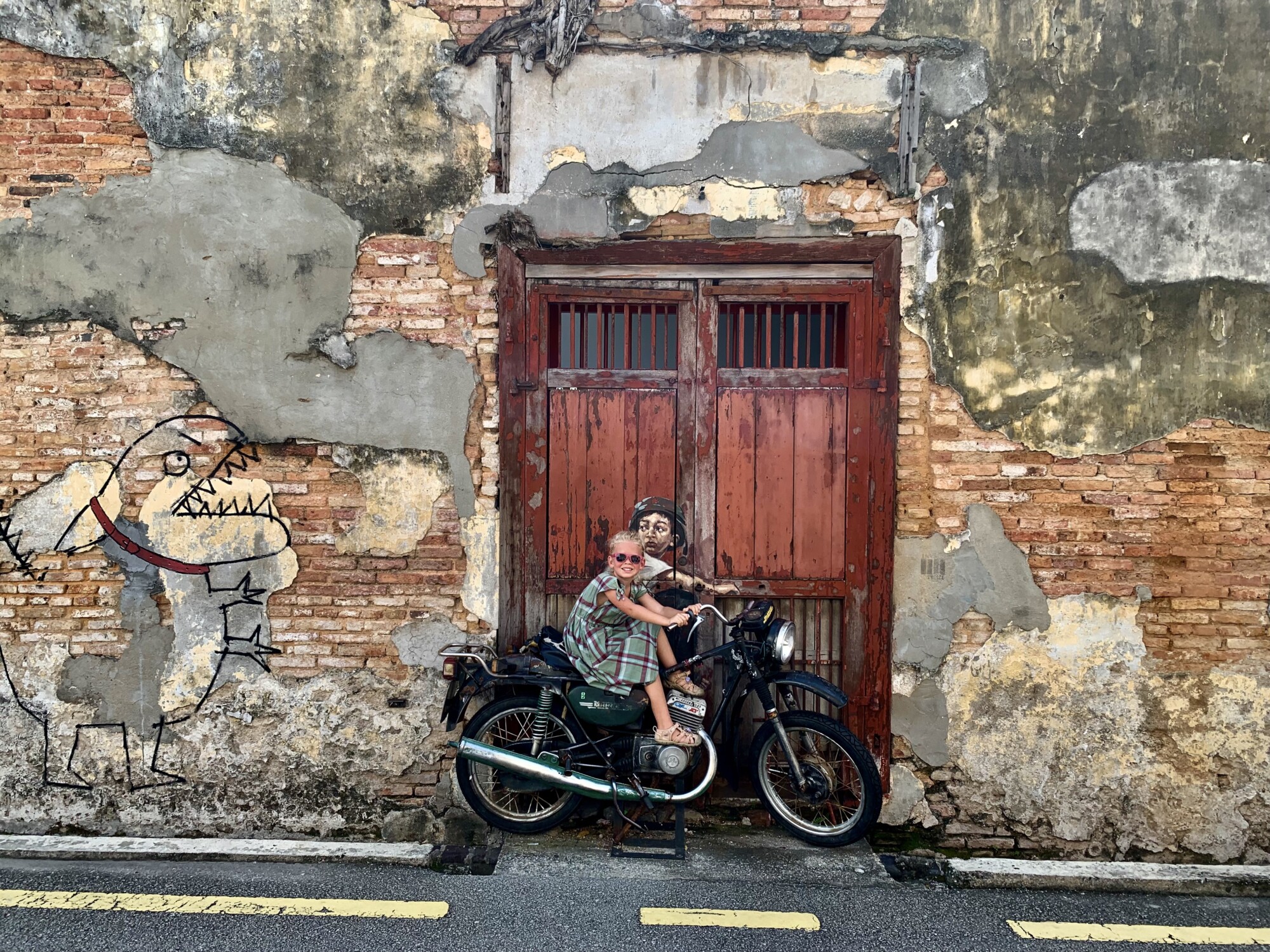 girl sitting on an interactive street art riding a motorcycle