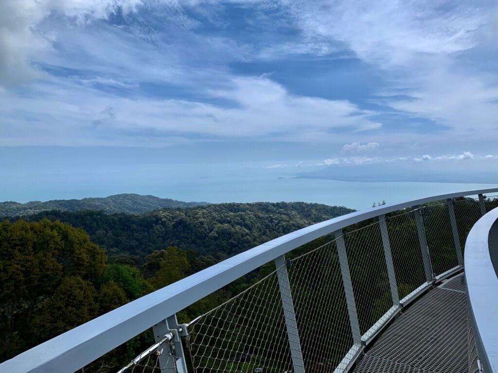 view from a bridge looking out over an island with the ocean in the distance