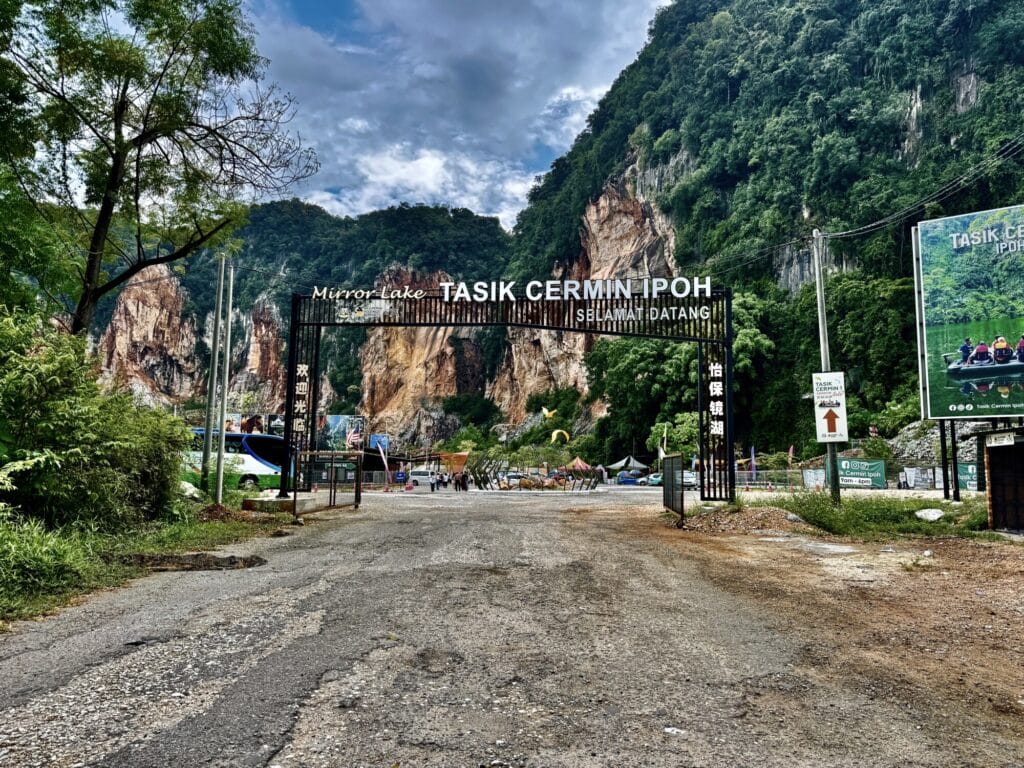 entrance to an attraction with the parking lot in mid ground and limestone cliffs in background