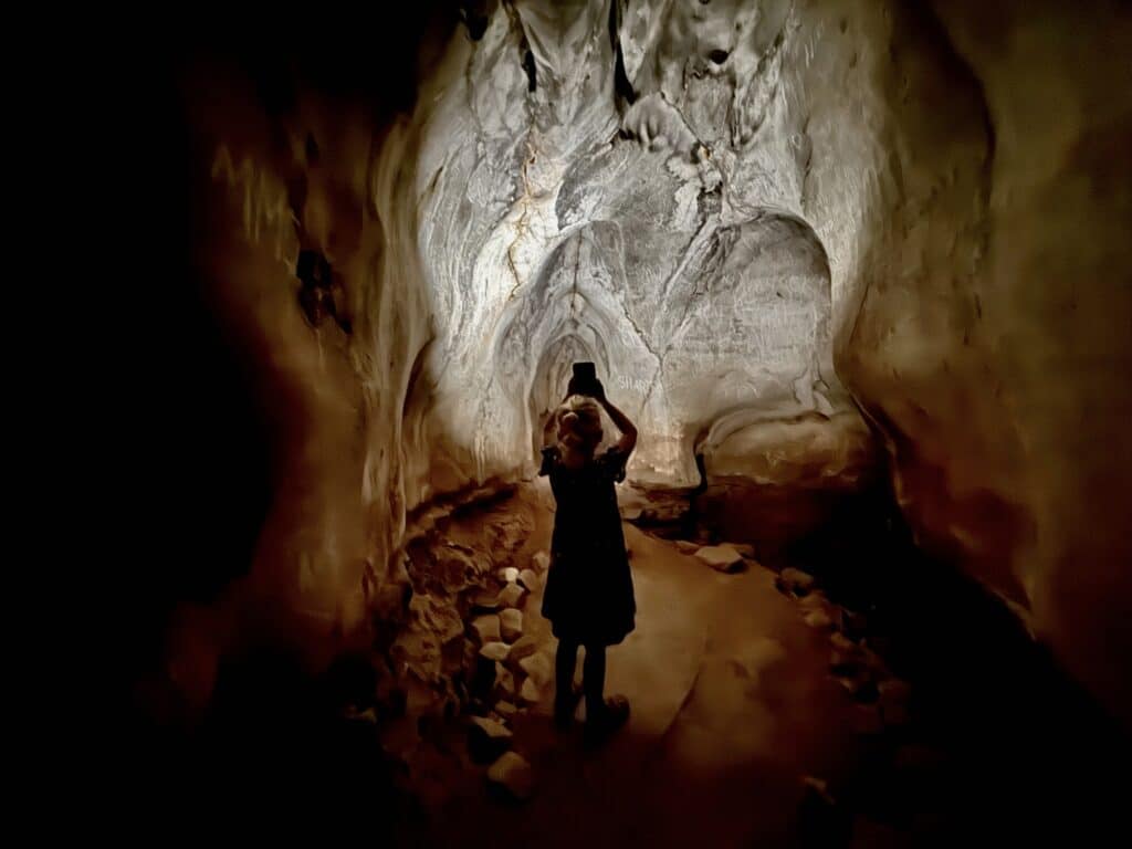 girl holding a flashlight in a cave