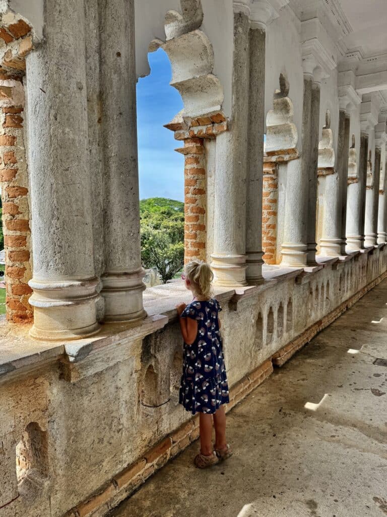 girl looking out into a courtyard from an interior walkway