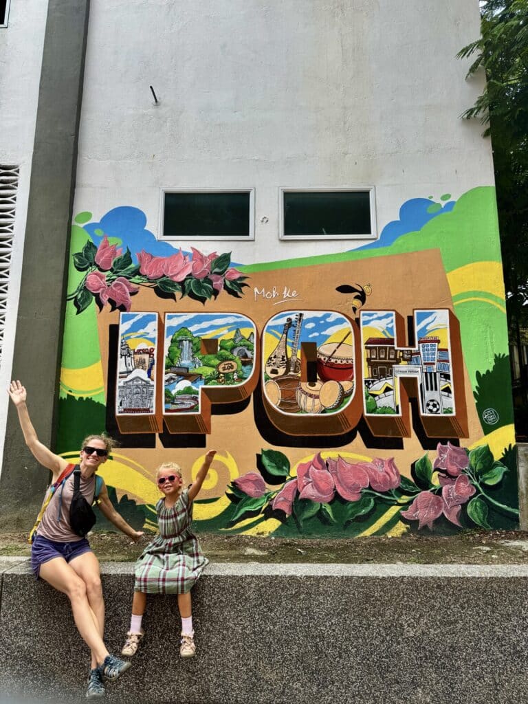 a woman and a girl posing in front of a sign that says IPOH