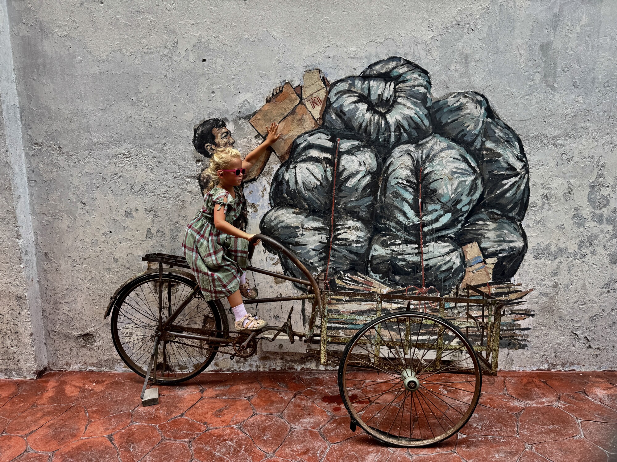 a girl with an interactive street mural riding a bicycle rickshaw