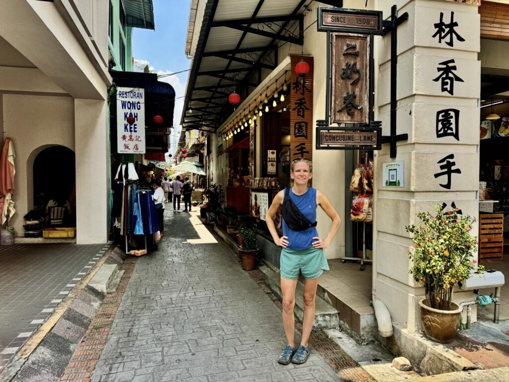 woman posing in front of a narrow lane