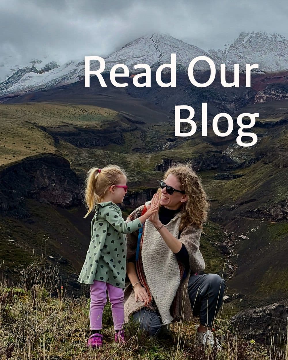 girl and woman clapping hands in front of a mountain