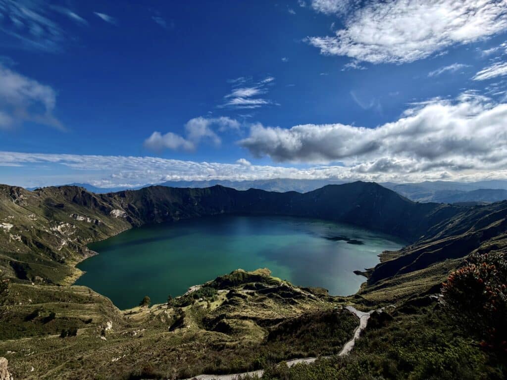 a crater lake with turquoise water and blue skies