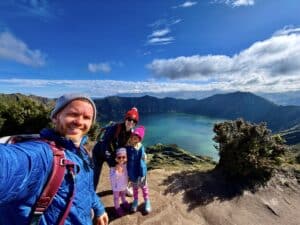 a family posing at the top of a crater lake