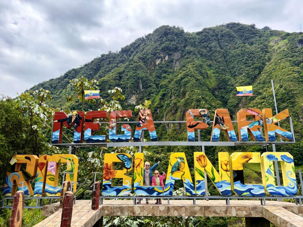 two girls posing in front of a large sign
