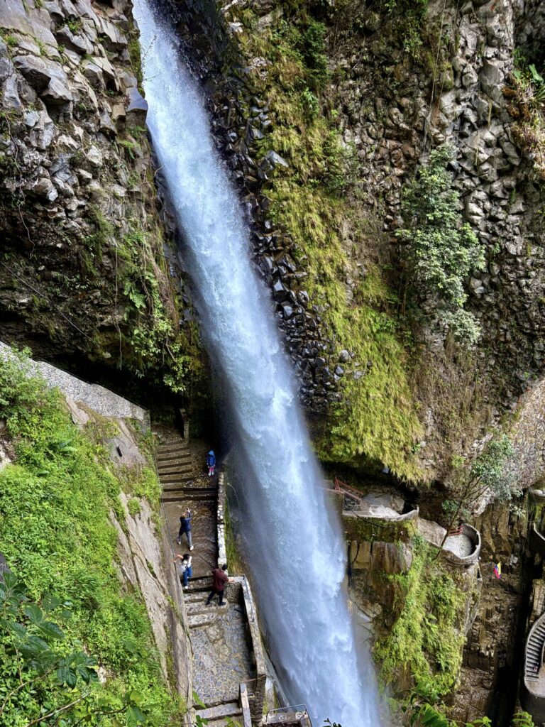 girl in blue standing under a waterfall