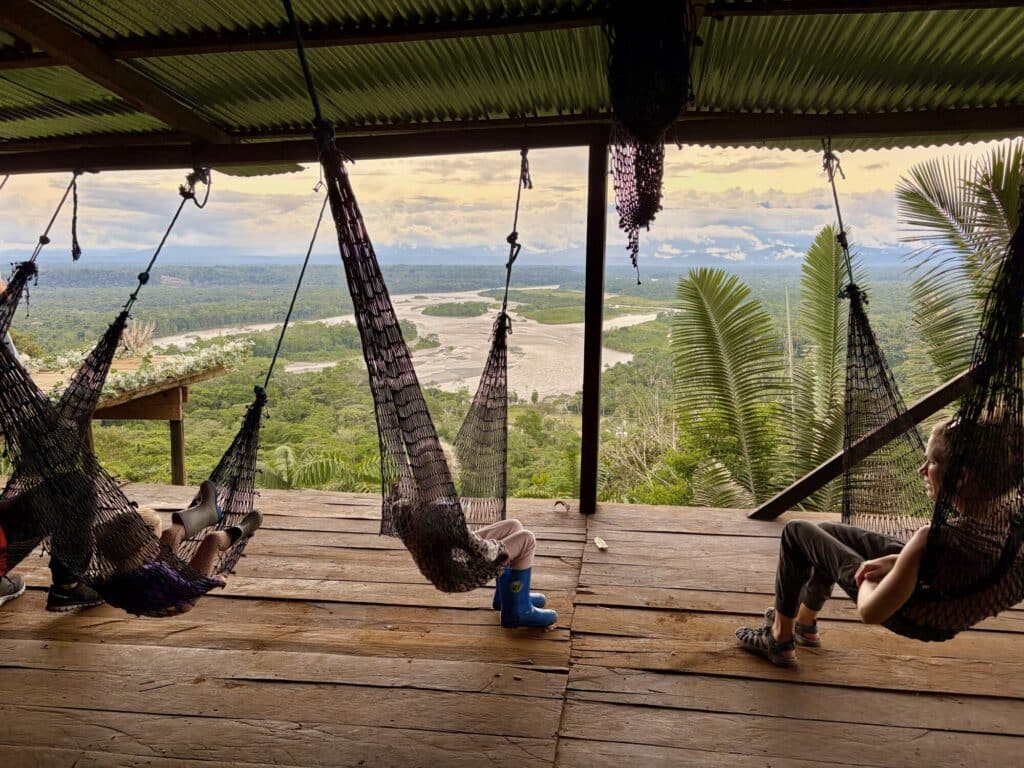 people sitting on a hammock overlooking the Amazon Rainforest