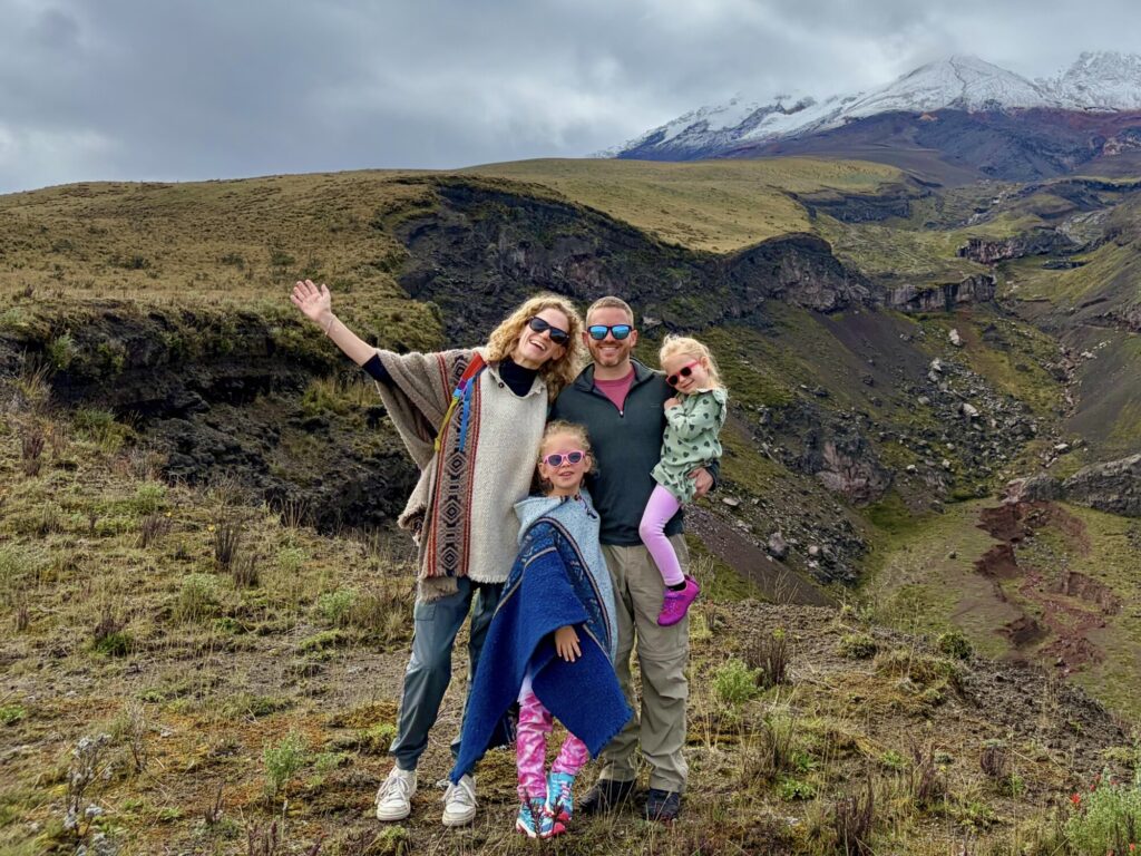 family posing in front of a volcano covered by clouds