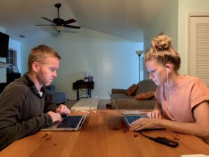 two people working at lap top computers