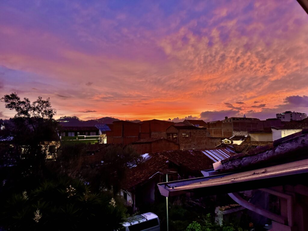 sunset with orange, purples, and yellows overlooking houses