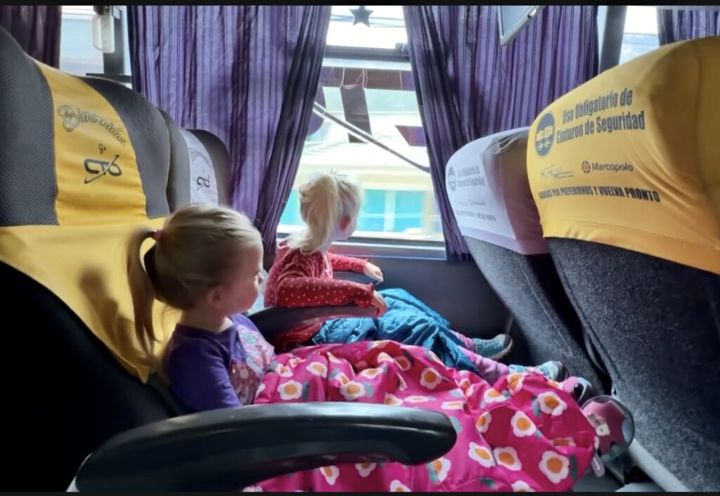 two kids sitting on a public bus