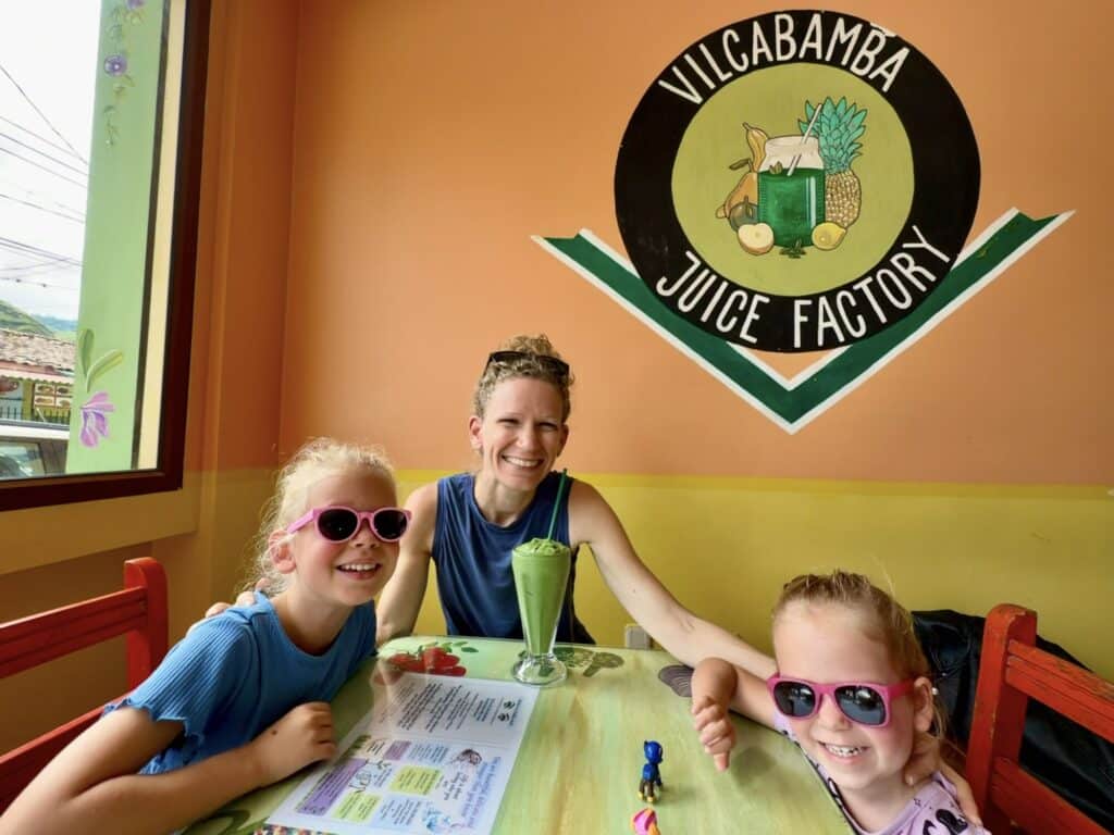 two girls and a mother getting their picture taken at a juice restaurant