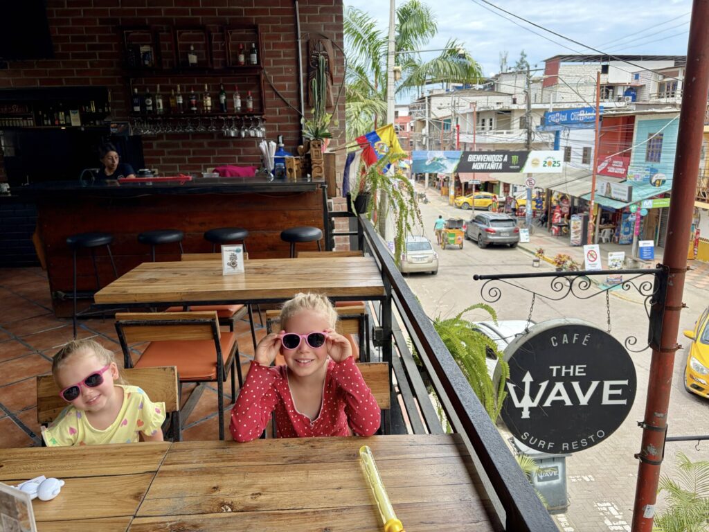 two girls waiting at a cafe with the local streets in the backgrou d