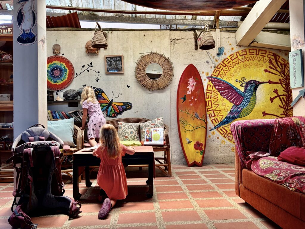 two kids reading books with a colorful hummingbird mural